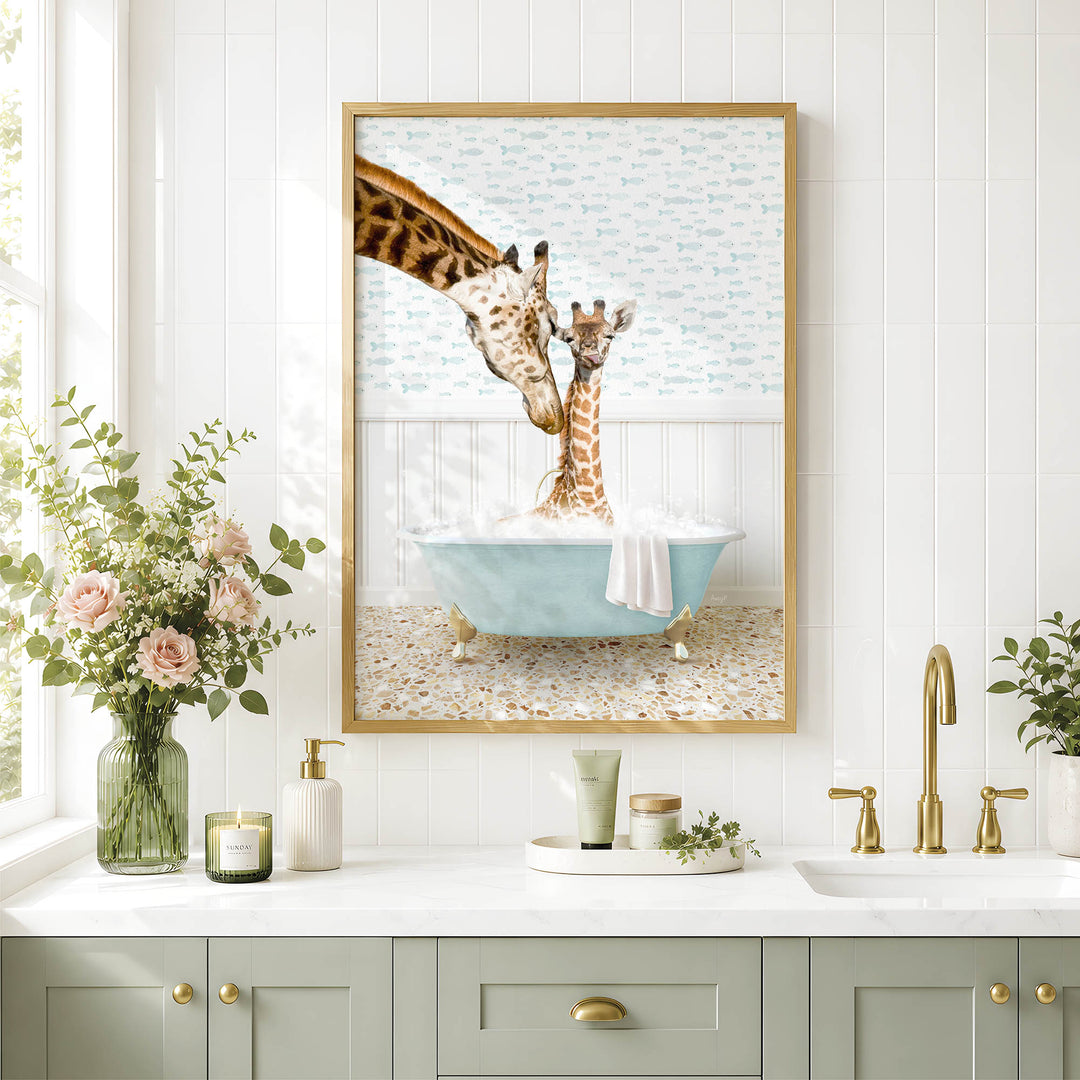 A framed image of two giraffes in a bathtub, surrounded by a floral arrangement and a white countertop with various toiletries.
