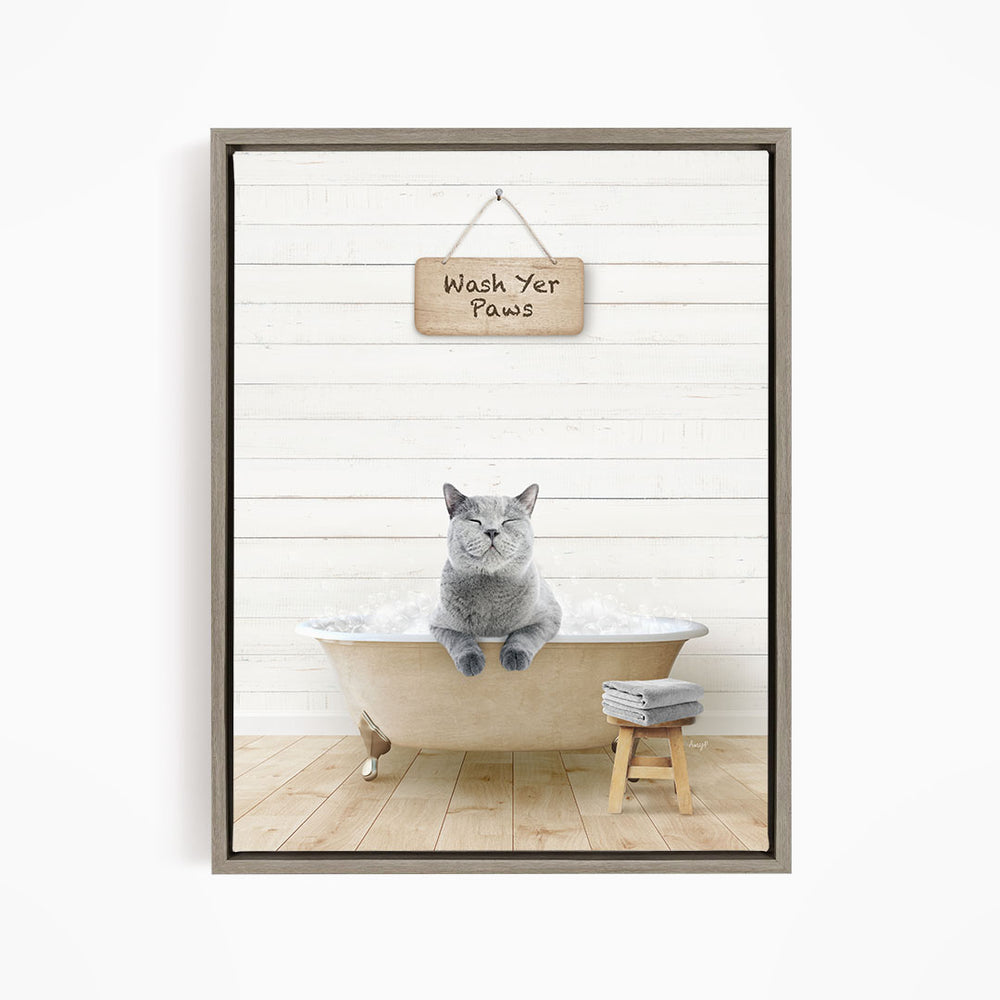 A gray cat sitting in a bathtub, with a wooden sign above that says "Wash Your Paws".