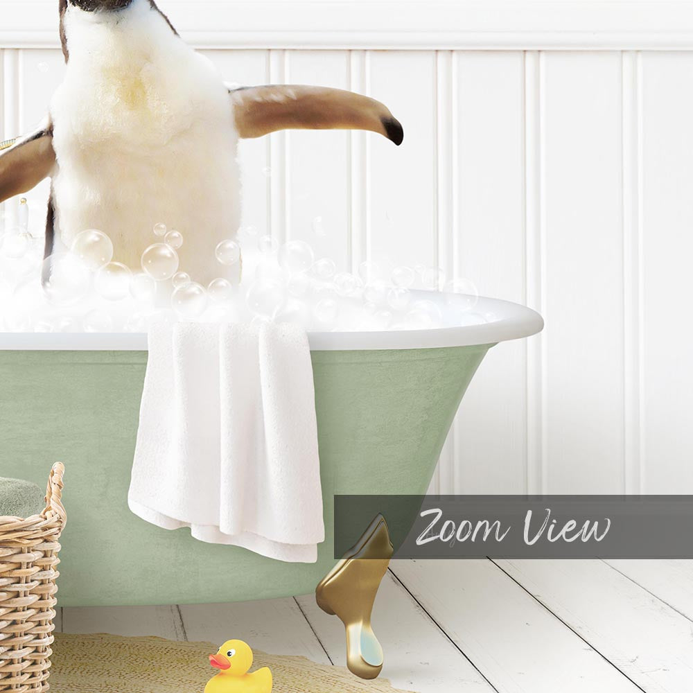 A penguin standing in a bathtub filled with bubbles, with a towel and rubber duck nearby.