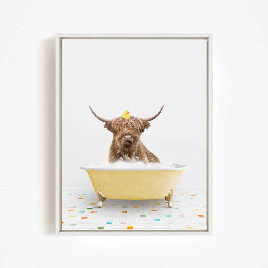 A brown cow with long horns is sitting in a yellow bathtub filled with bubbles, with a rubber duck perched on its head.