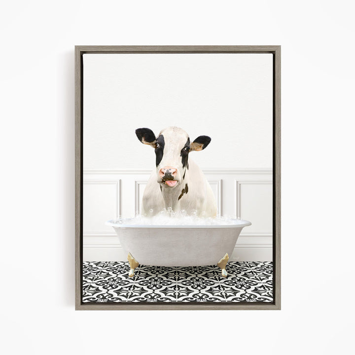A black and white cow is sitting in a white bathtub filled with water, creating a whimsical and humorous scene.