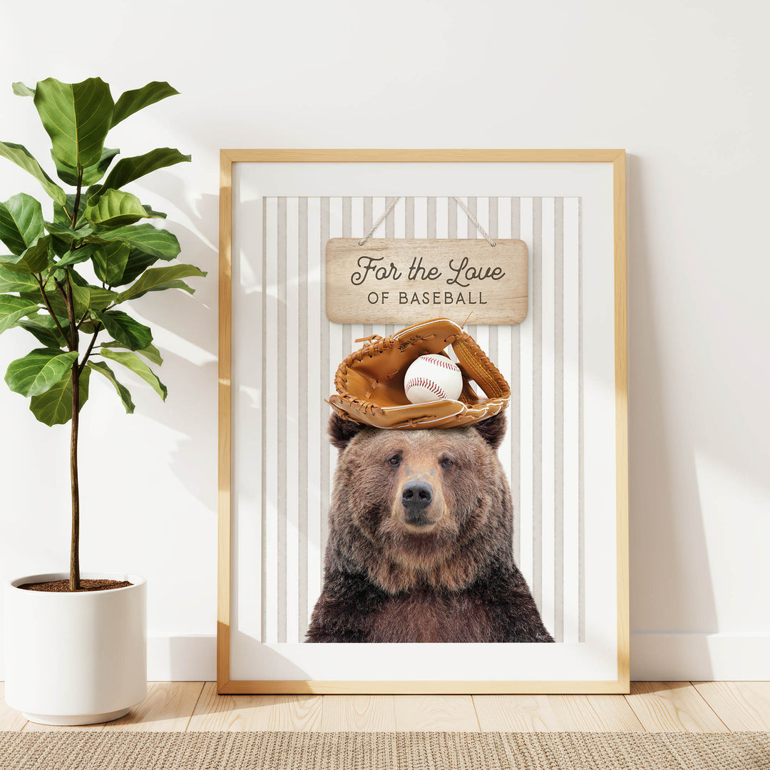 A framed print of a brown bear wearing a baseball glove and ball, with a sign above that says "For the Love of Baseball".