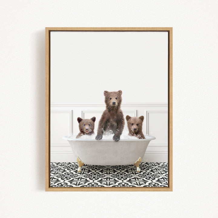 Three adorable brown bears sitting in a white bathtub, with one bear sitting on the edge of the tub and the other two bears sitting inside the tub.