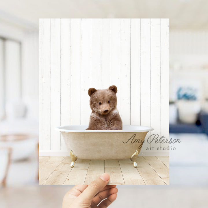 a small brown bear sitting in a bath tub