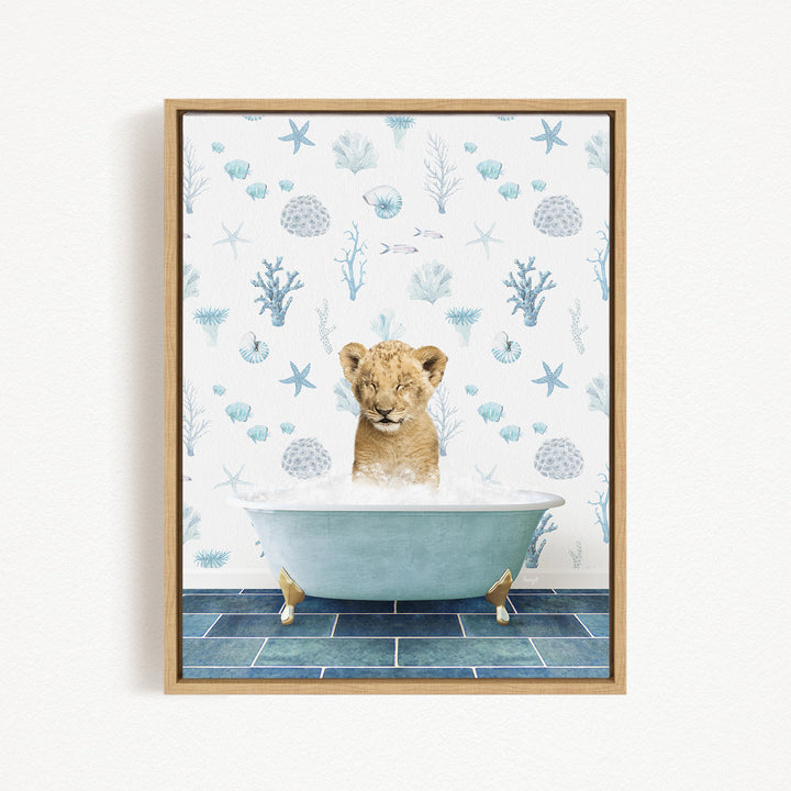 A young lion cub is sitting in a blue bathtub filled with water, surrounded by a pattern of seashells, starfish, and other marine life.