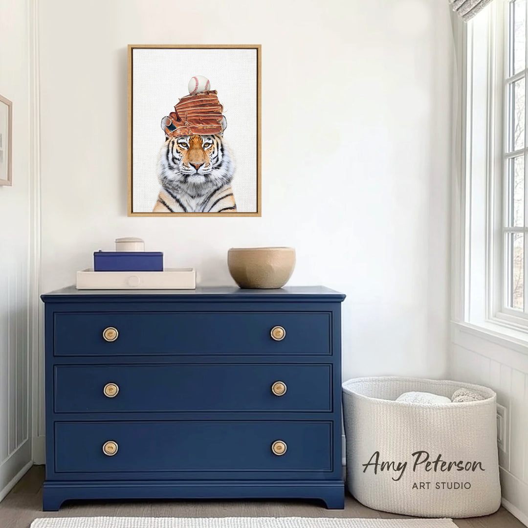 a blue dresser with a framed picture of a tiger wearing a hat, and a white basket with the text " Amy Peterson ART STUDIO" printed on it.