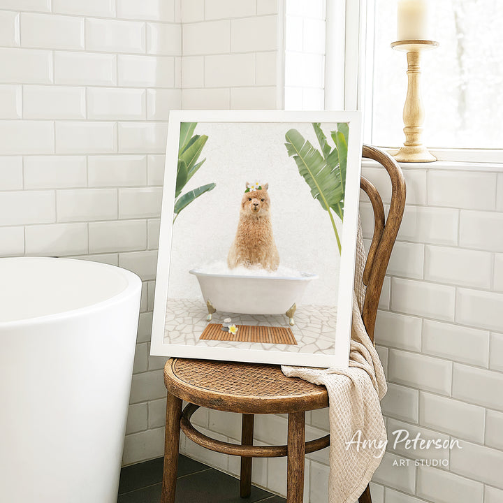 A framed image of a dog sitting in a bathtub, surrounded by tropical plants, is displayed on a wooden chair in a bathroom setting.