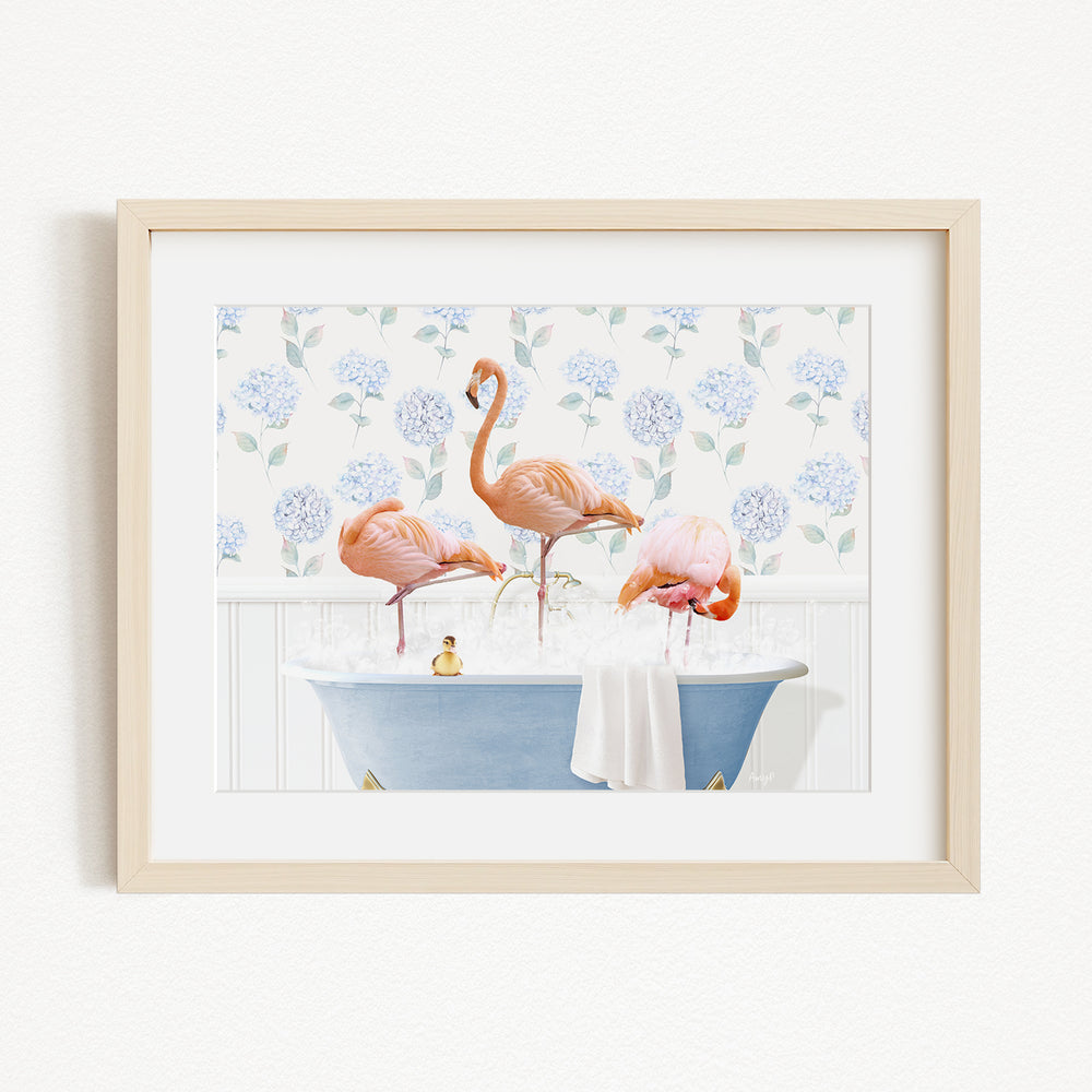 A framed image depicting three flamingos standing in a blue bathtub filled with water, surrounded by a floral pattern.
