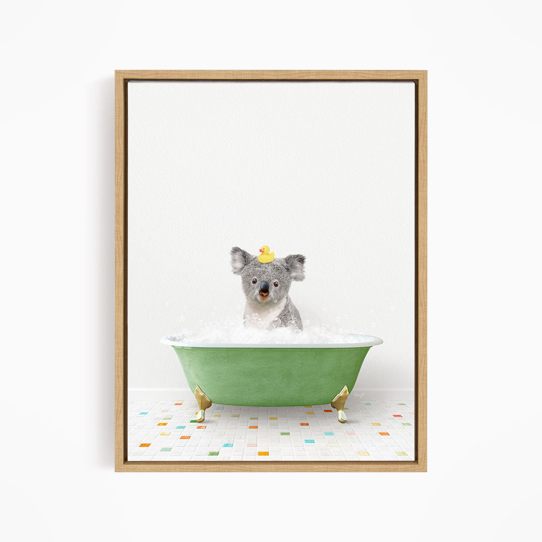 A koala bear sitting in a green bathtub filled with bubbles, wearing a yellow rubber duck hat.