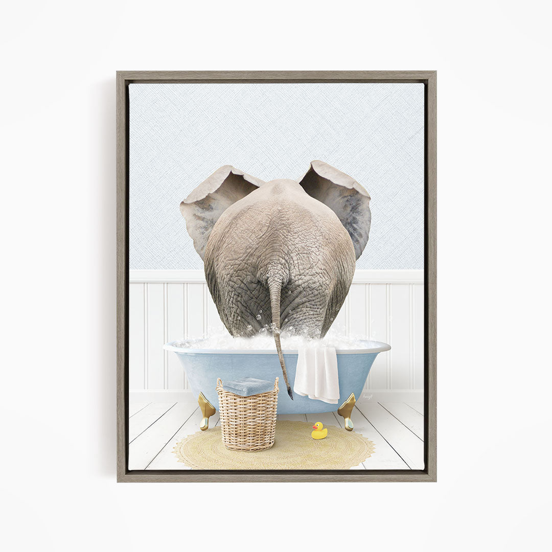 A gray elephant is standing in a blue bathtub filled with water, surrounded by a yellow rubber duck and a basket.