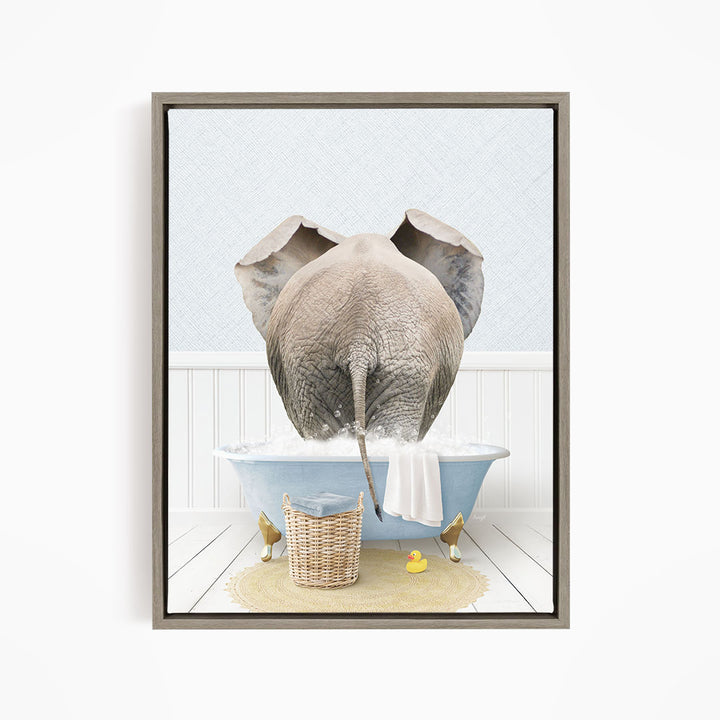 A gray elephant is standing in a blue bathtub filled with water, surrounded by a yellow rubber duck and a basket.