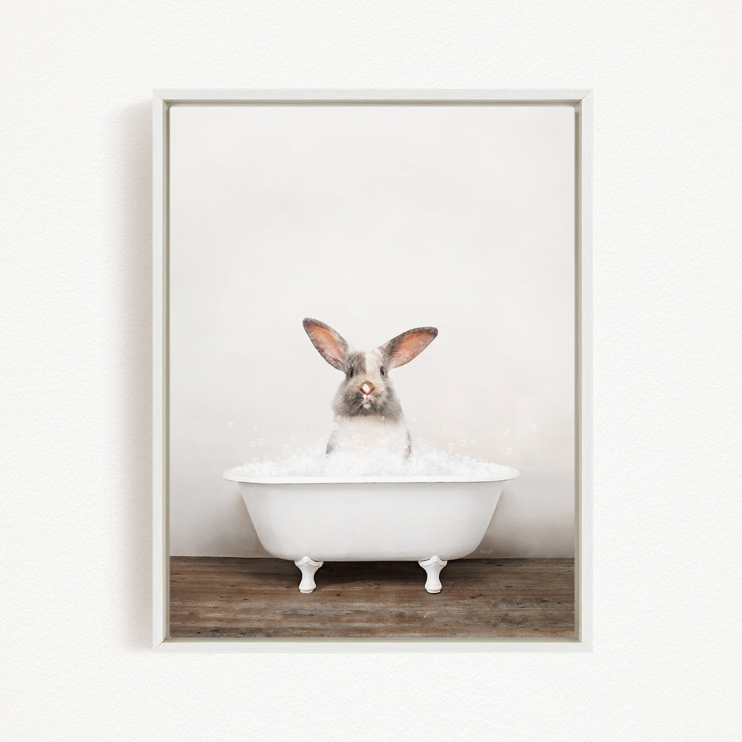 A white rabbit sitting in a white bathtub filled with water, with its head raised and ears perked up.