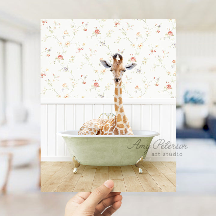 a hand holding up a picture of a giraffe in a bathtub