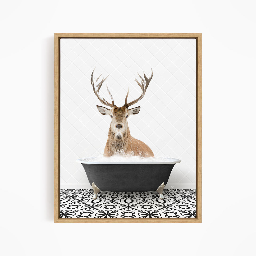 A deer with large antlers is sitting in a black bathtub filled with water, creating a whimsical and unexpected scene.