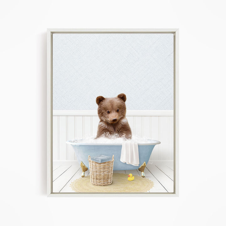 A brown bear sitting in a blue bathtub filled with water, surrounded by a yellow rubber duck and a basket.