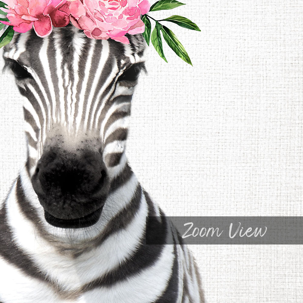 A close-up of a zebra's face with a pink flower crown on its head, against a plain white background.