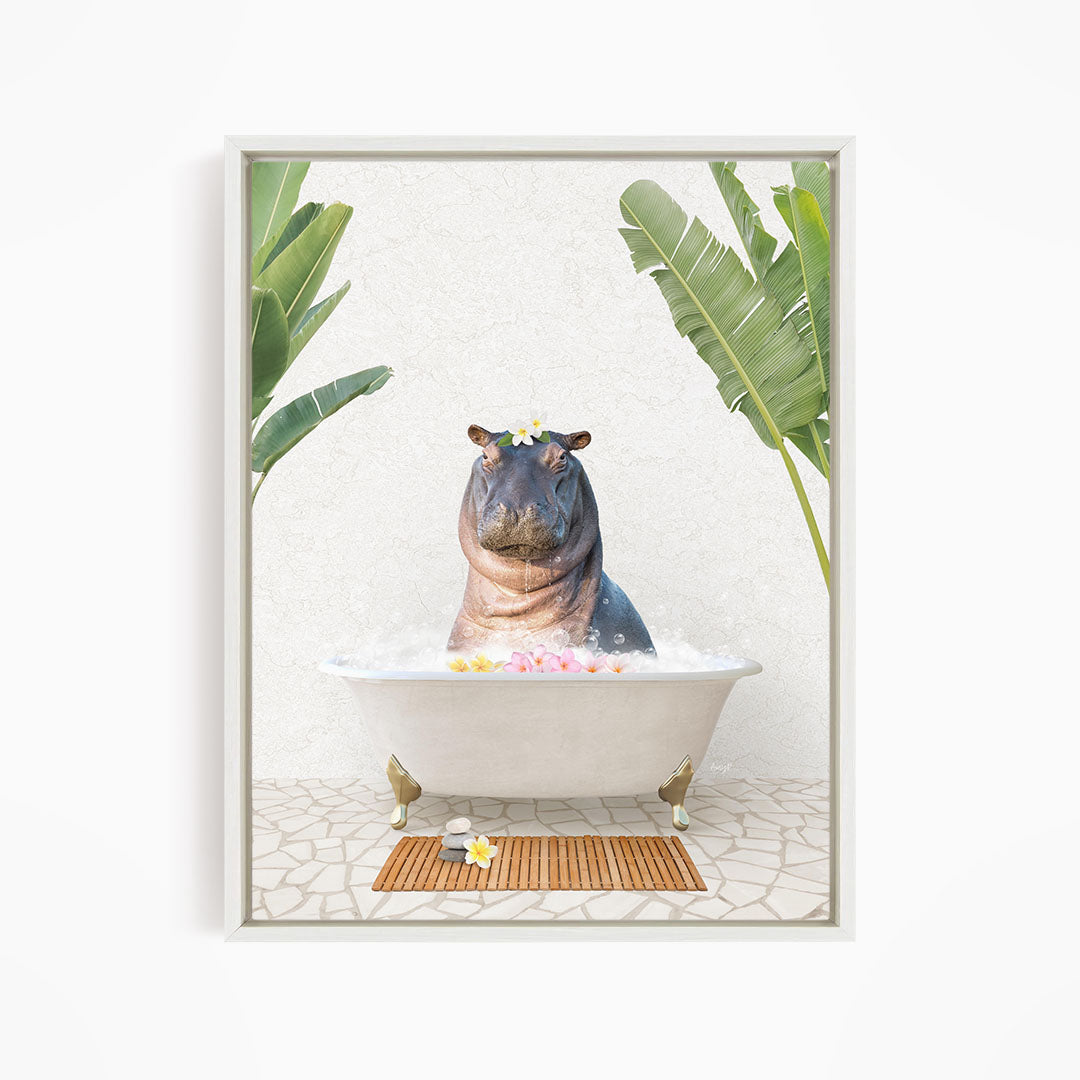 A framed image depicting a hippopotamus sitting in a bathtub filled with bubbles, surrounded by tropical plants and a wooden mat.