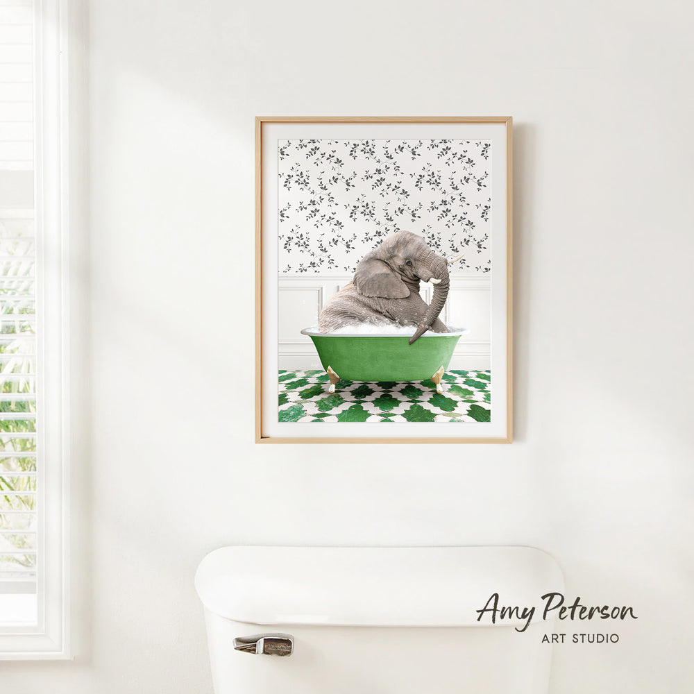 A framed image of a gray elephant sitting in a green bathtub, with a patterned wall behind it.
