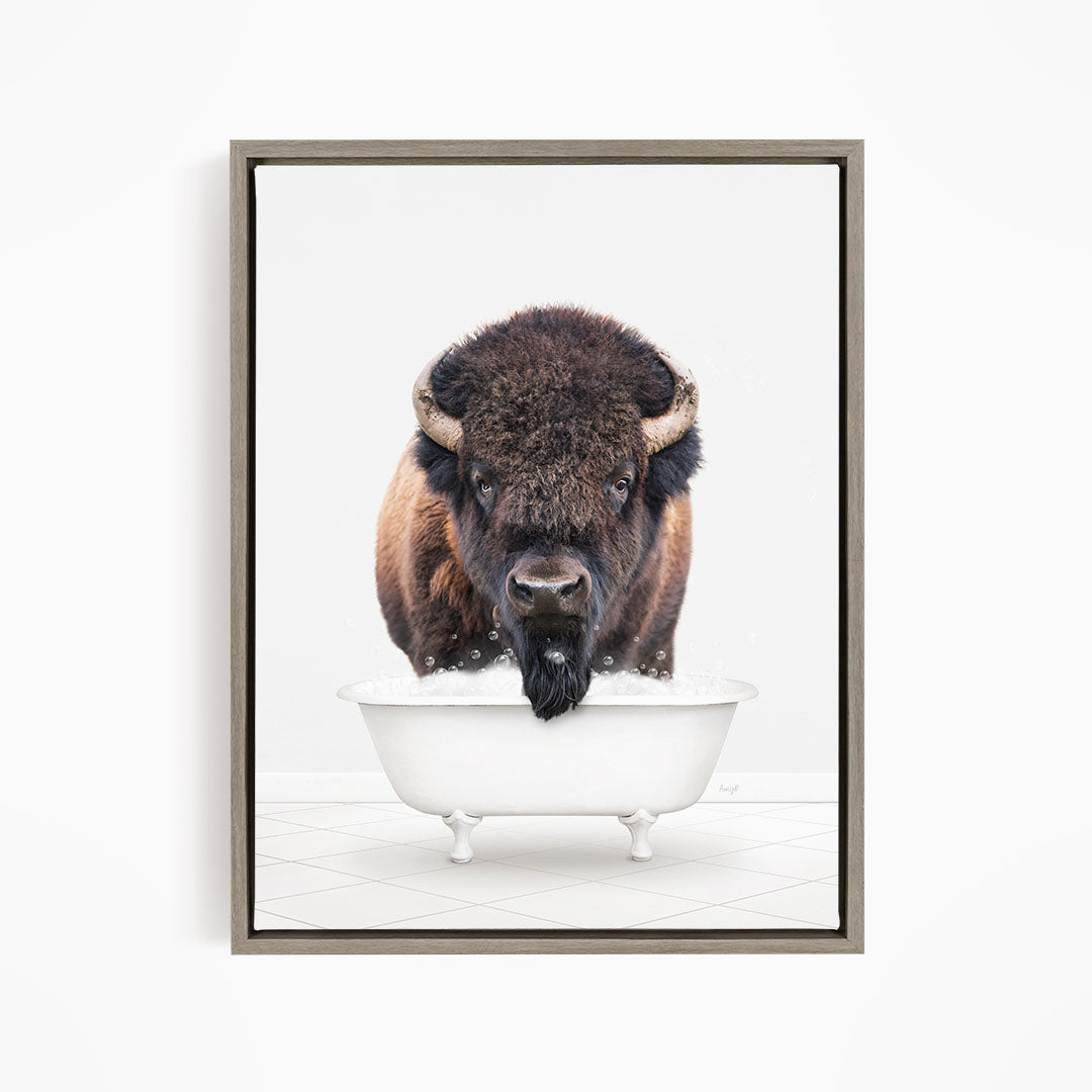A buffalo with a long beard is standing in a white bathtub, looking directly at the camera.