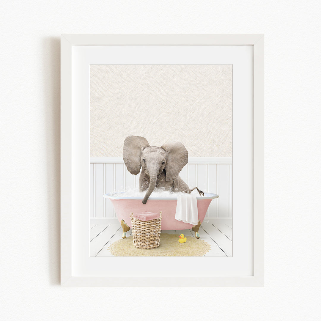 A baby elephant sitting in a pink bathtub, surrounded by a yellow rubber duck and a basket of bath toys.