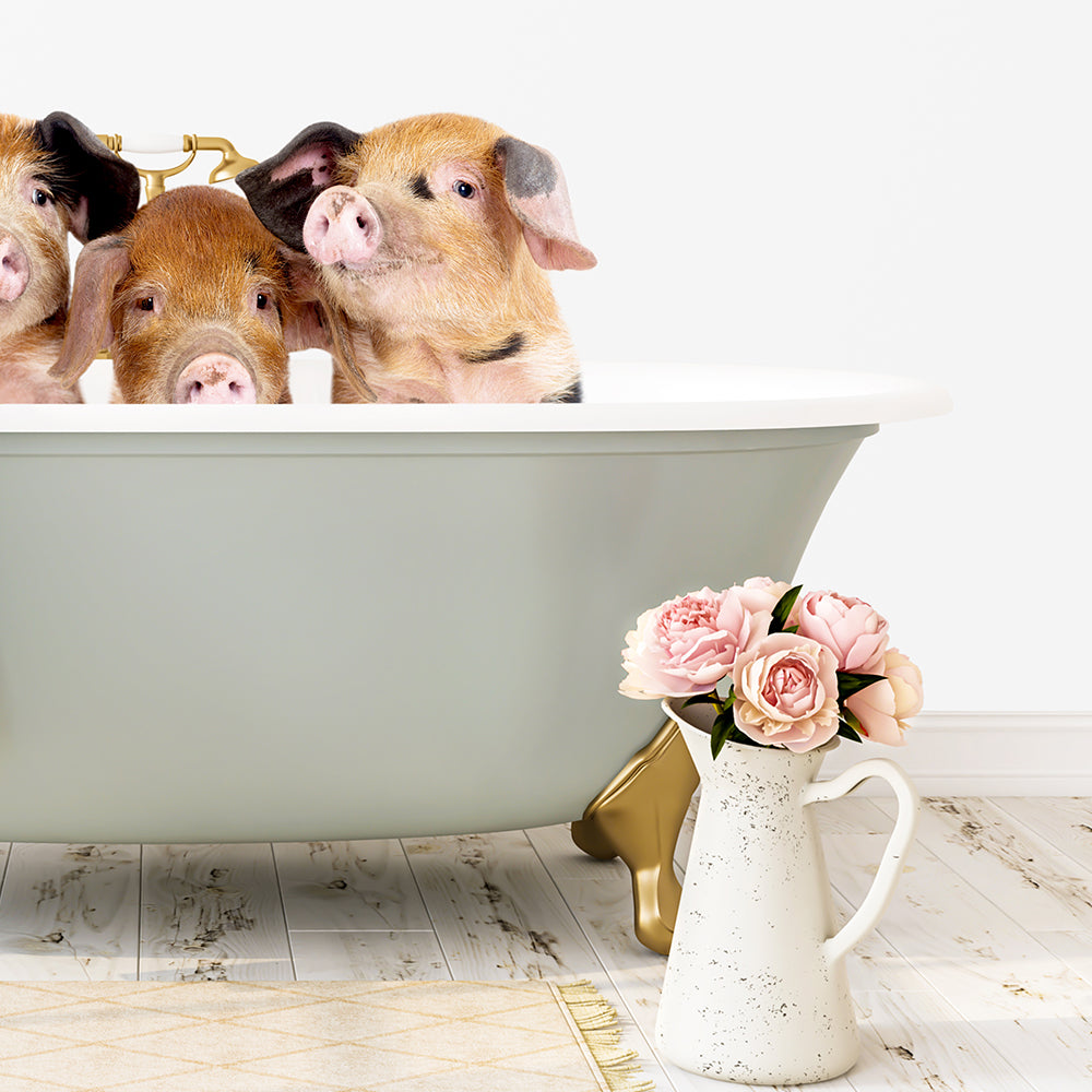 Three adorable pigs sitting in a green bathtub, with a vase of pink flowers on the floor next to them.