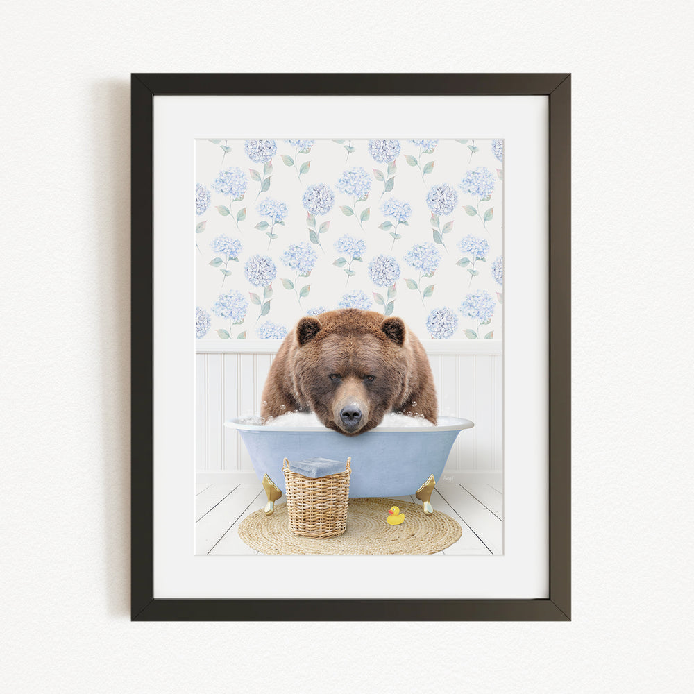 A brown bear is sitting in a blue bathtub filled with water, surrounded by a wicker basket and yellow rubber ducks.