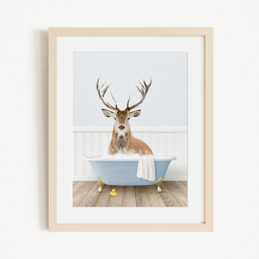 A deer with antlers is sitting in a blue bathtub filled with water, surrounded by yellow rubber duckies.
