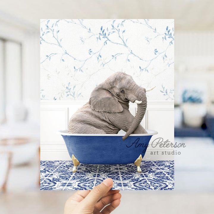 a person holding up a card with an elephant in a bathtub