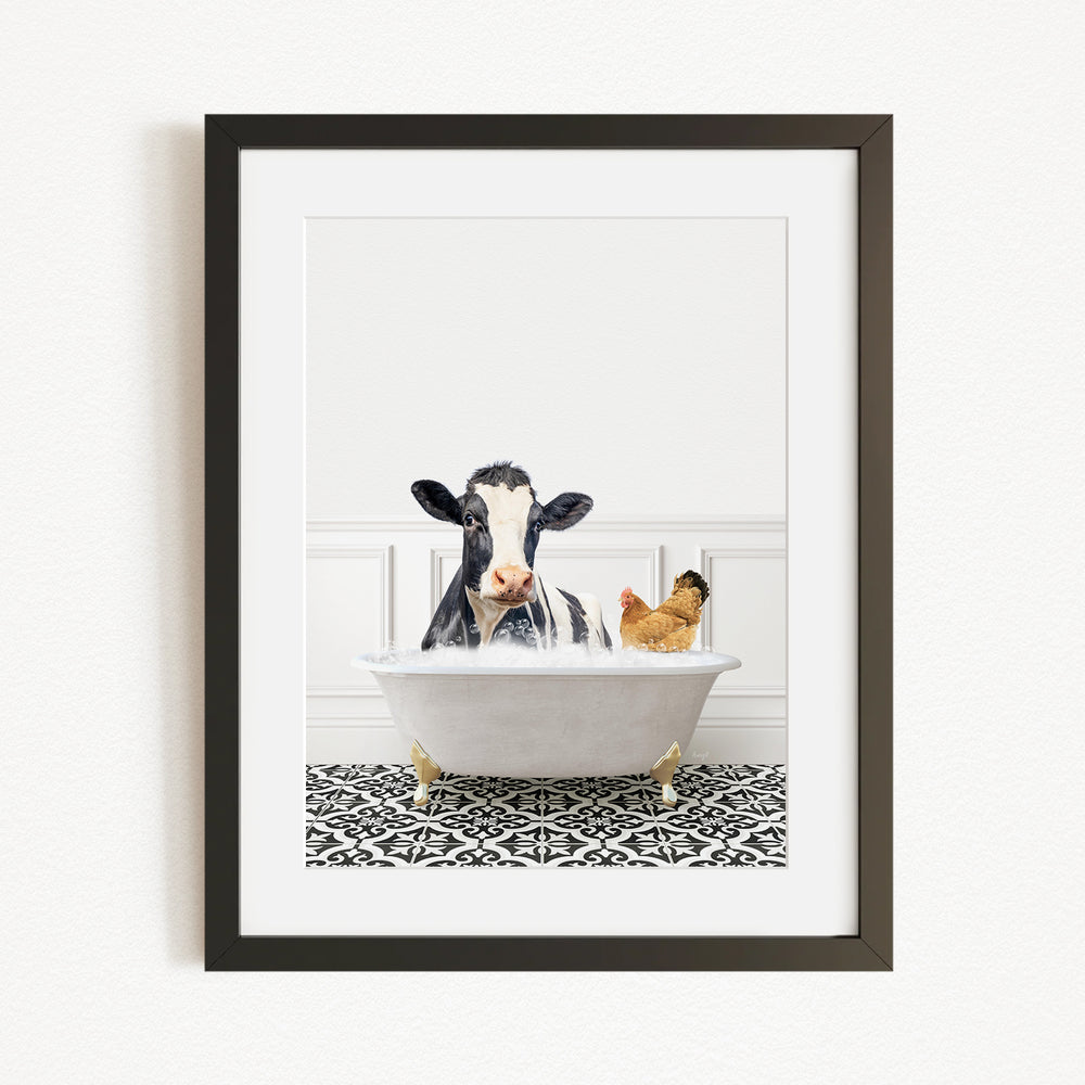 A black and white cow is sitting in a white bathtub, with a chicken standing nearby, in a framed image.