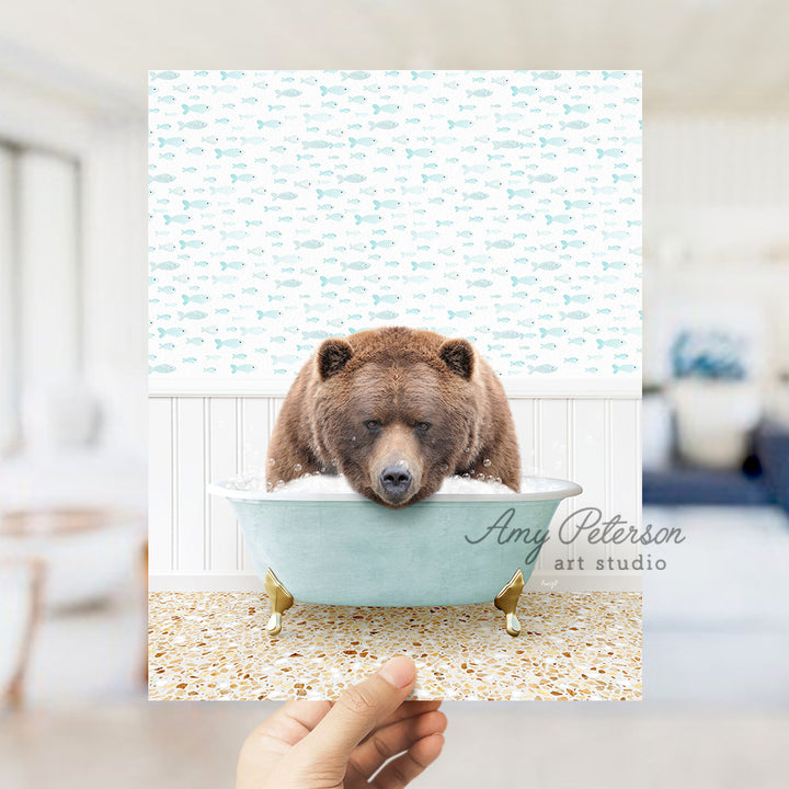 a person holding up a picture of a bear in a bathtub