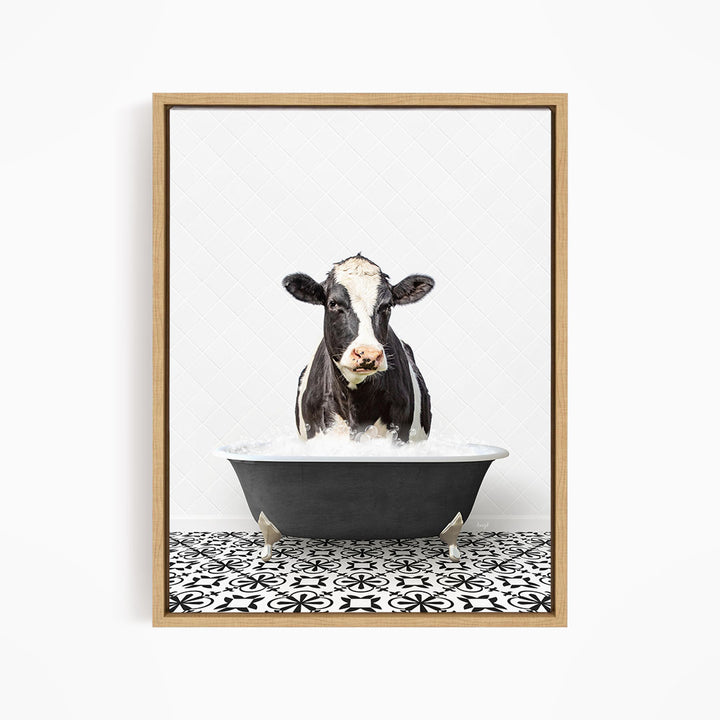 A black and white cow is standing in a bathtub filled with water, creating a whimsical and humorous scene.