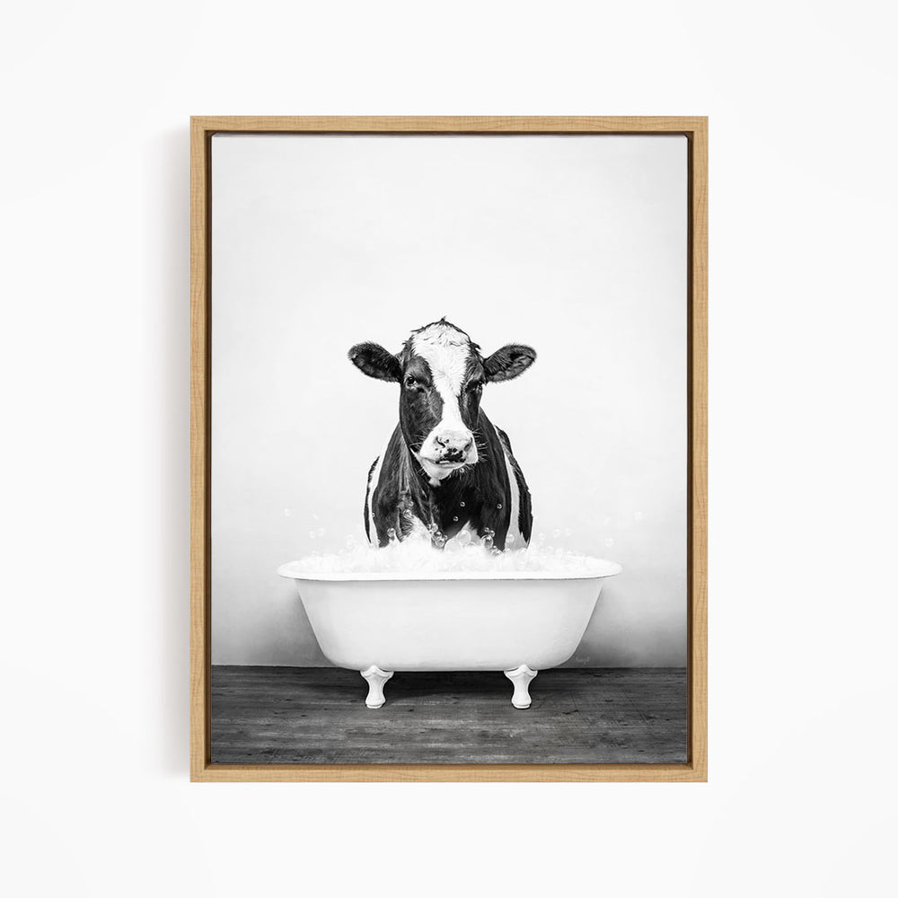 A black and white image of a cow standing in a bathtub filled with water.