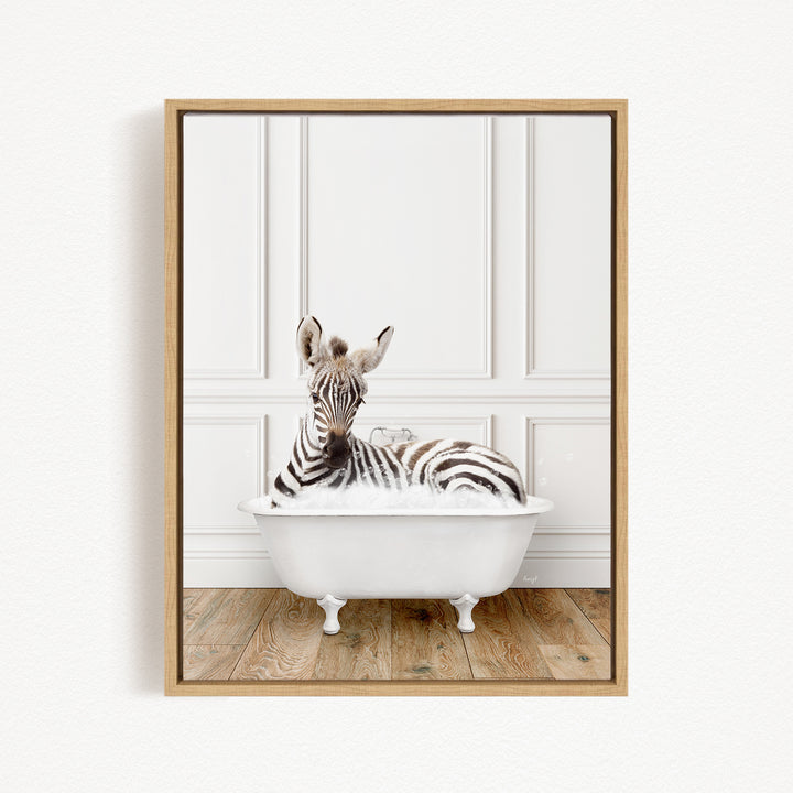 A zebra is sitting in a white bathtub, surrounded by a wooden floor and white walls.
