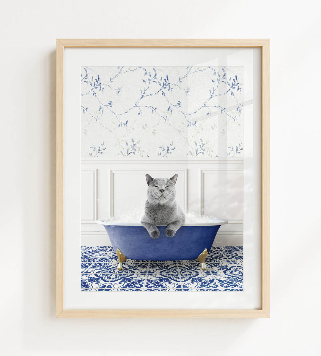A gray cat sitting in a blue bathtub filled with bubbles, with a patterned tile floor and a floral wallpaper in the background.