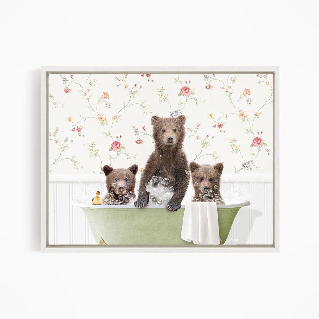 Three adorable brown bears sitting in a green bathtub, surrounded by a floral wallpaper.