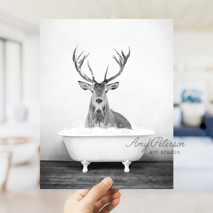 a person holding up a card with a picture of a deer in a bathtub