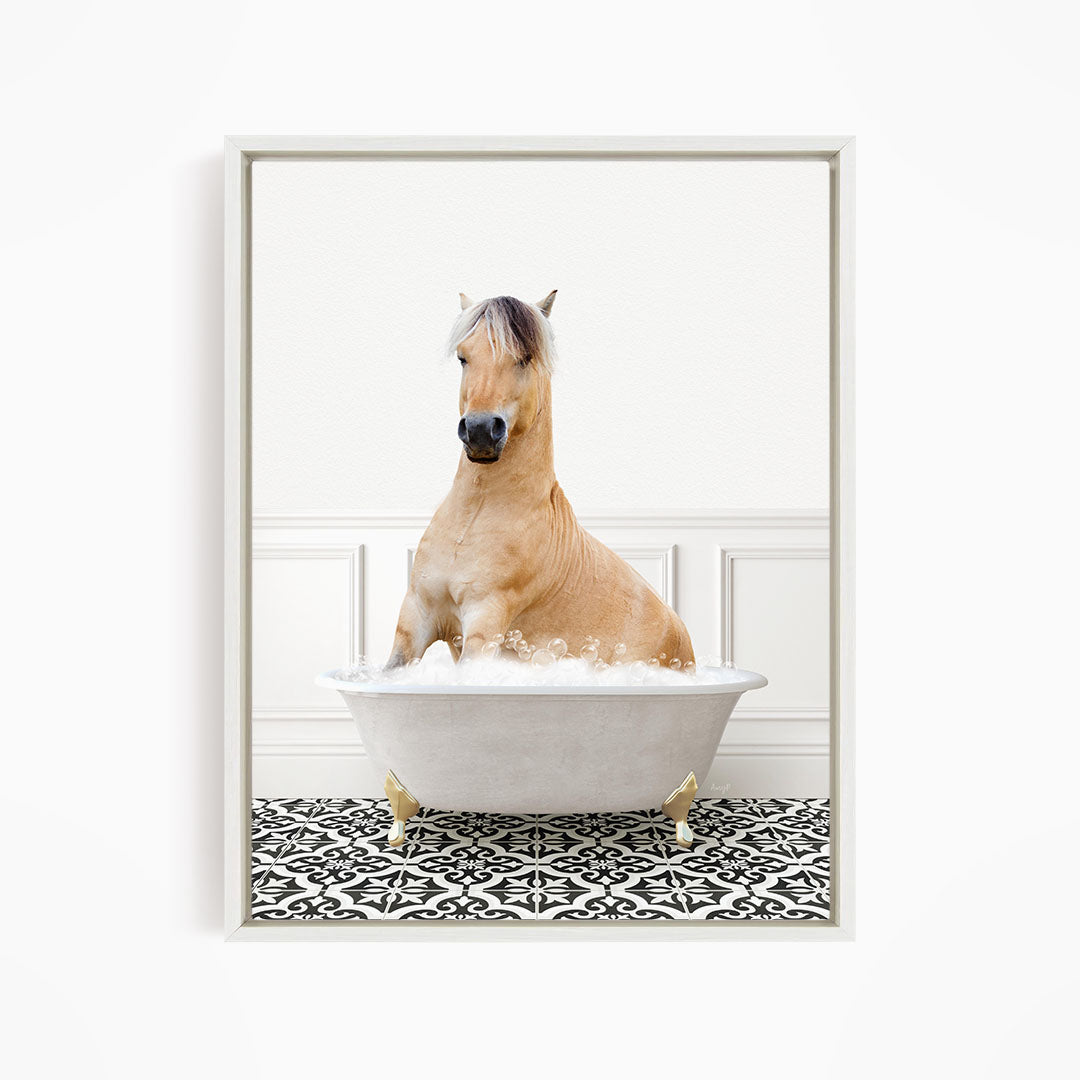 A light brown horse is sitting in a white bathtub filled with water, surrounded by a black and white patterned floor.