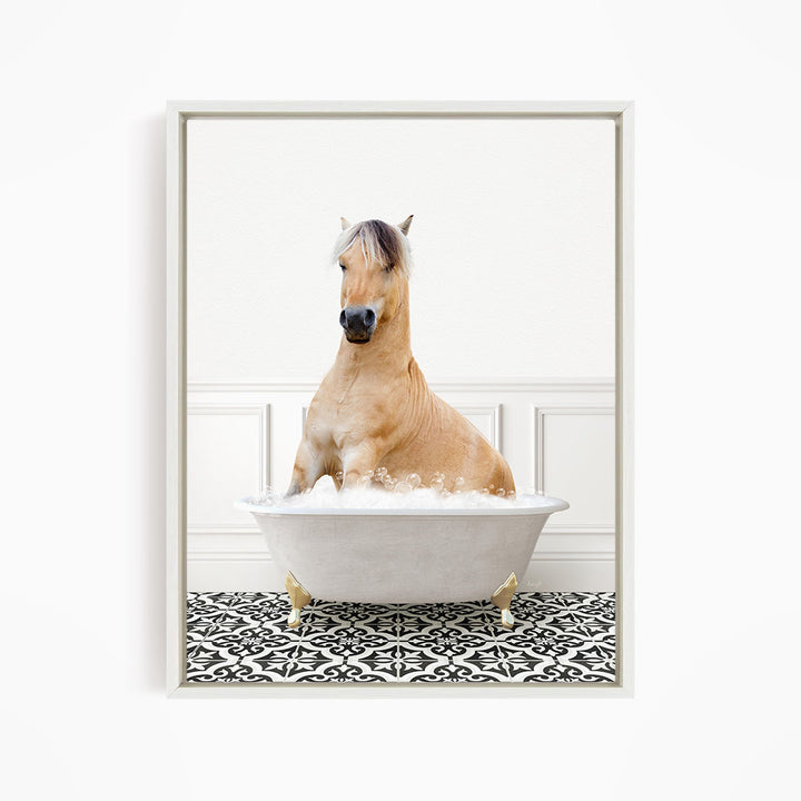 A light brown horse is sitting in a white bathtub filled with water, surrounded by a black and white patterned floor.