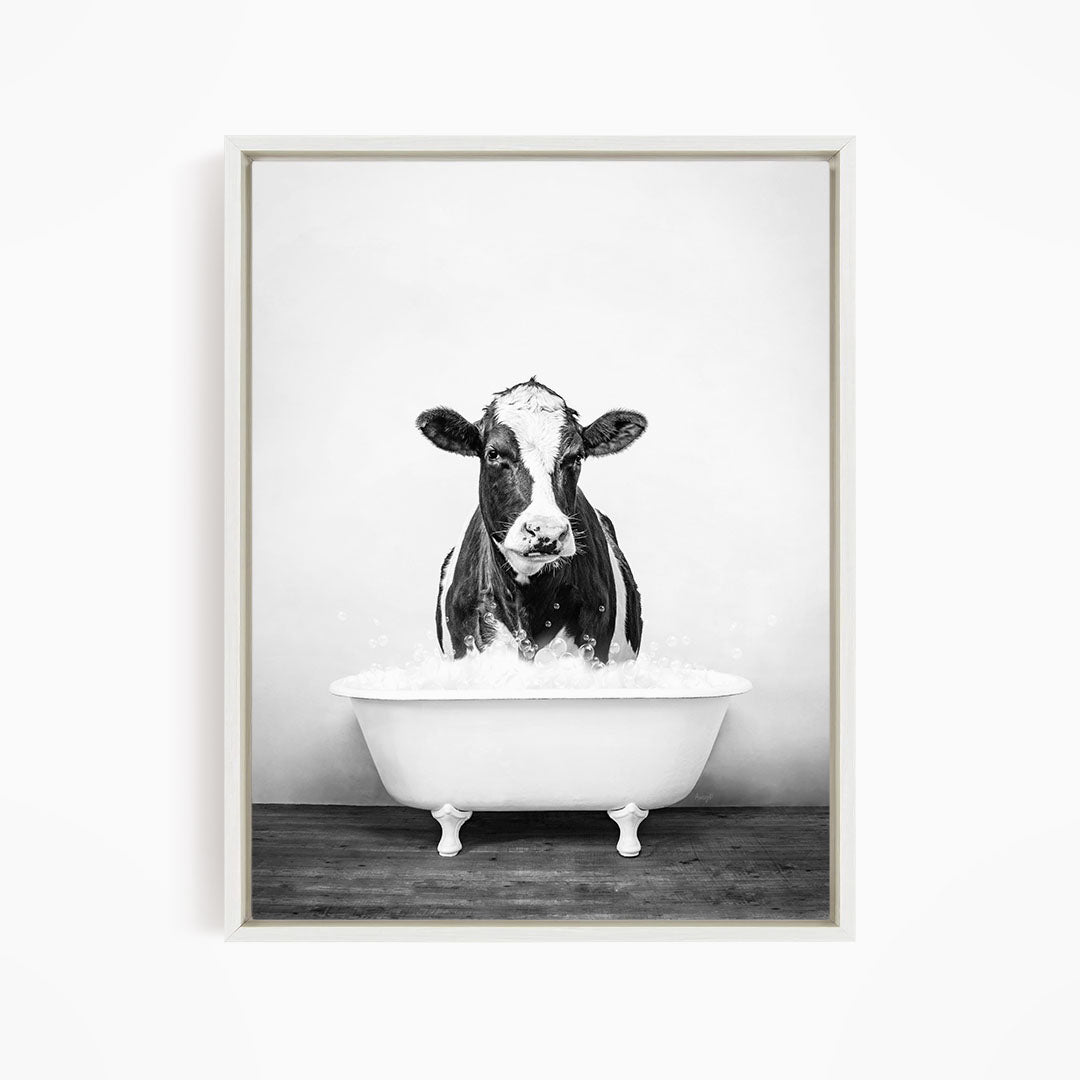 A black and white image of a cow standing in a bathtub filled with water.