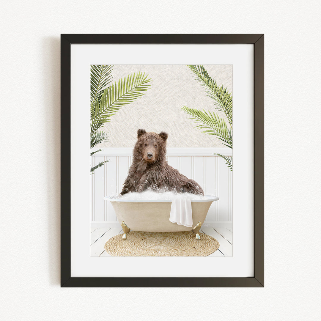 A brown bear sitting in a bathtub filled with bubbles, surrounded by green palm leaves.