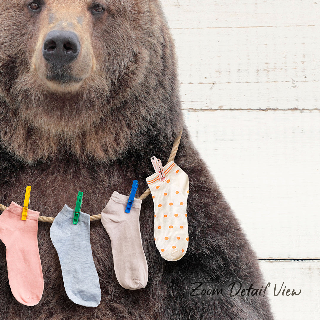 A large brown bear wearing a clothesline with colorful socks hanging on it.