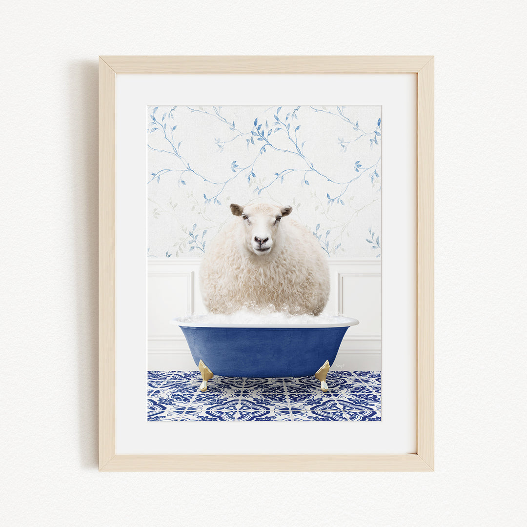 A fluffy white sheep sits in a blue bathtub, surrounded by a blue and white patterned rug and a white wall with blue floral wallpaper.