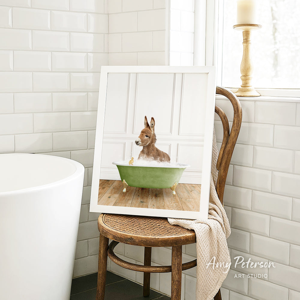 A framed image of a small animal, likely a rabbit or a similar creature, sitting in a green bathtub in a bathroom setting.