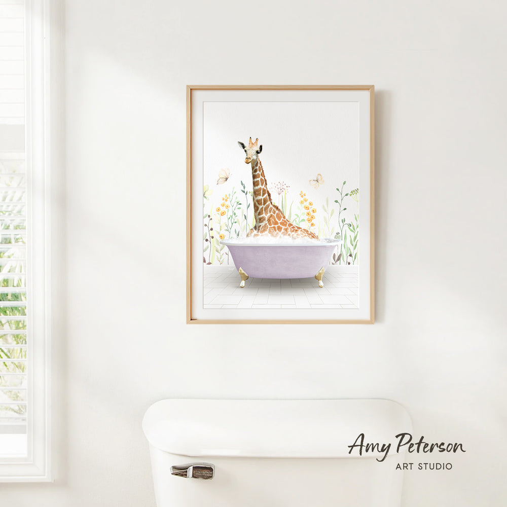 A framed illustration of a giraffe sitting in a bathtub surrounded by flowers and butterflies is hanging on a white wall.