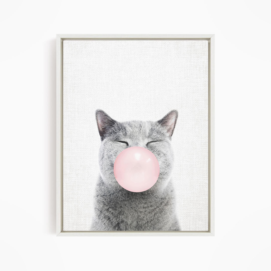 A gray cat with its eyes closed and a pink bubble blowing in its mouth.
