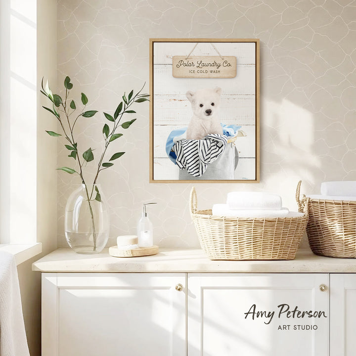 a framed picture of a polar bear sitting in a basket, hanging on a wall above a white cabinet with baskets.