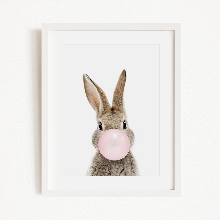 A cute rabbit blowing a pink bubble with its nose.