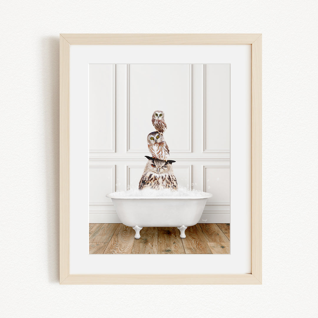 A framed image depicting a white bathtub filled with water, with a stack of owls perched on top of it.