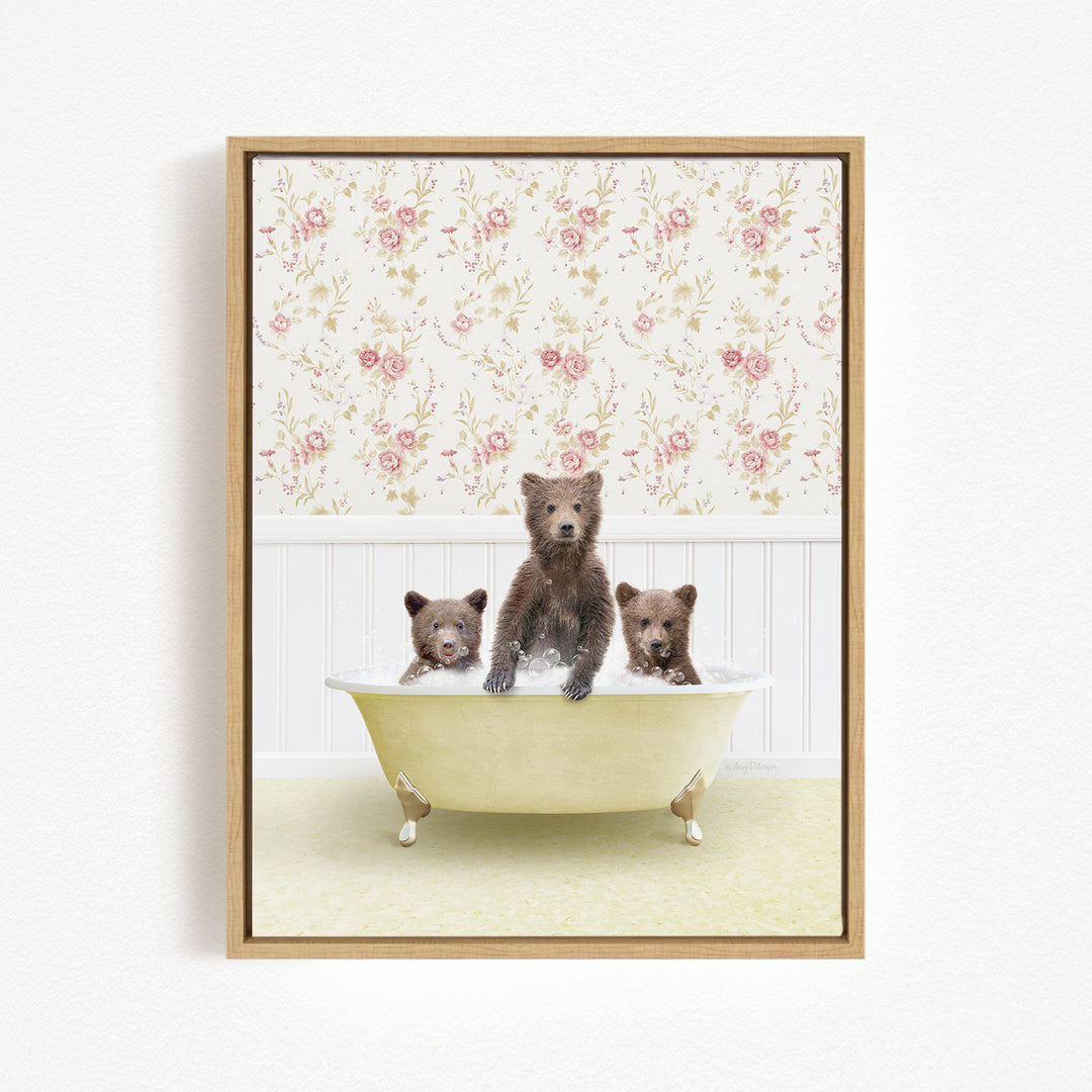 A framed image depicting three bears sitting in a bathtub, with a floral wallpaper in the background.