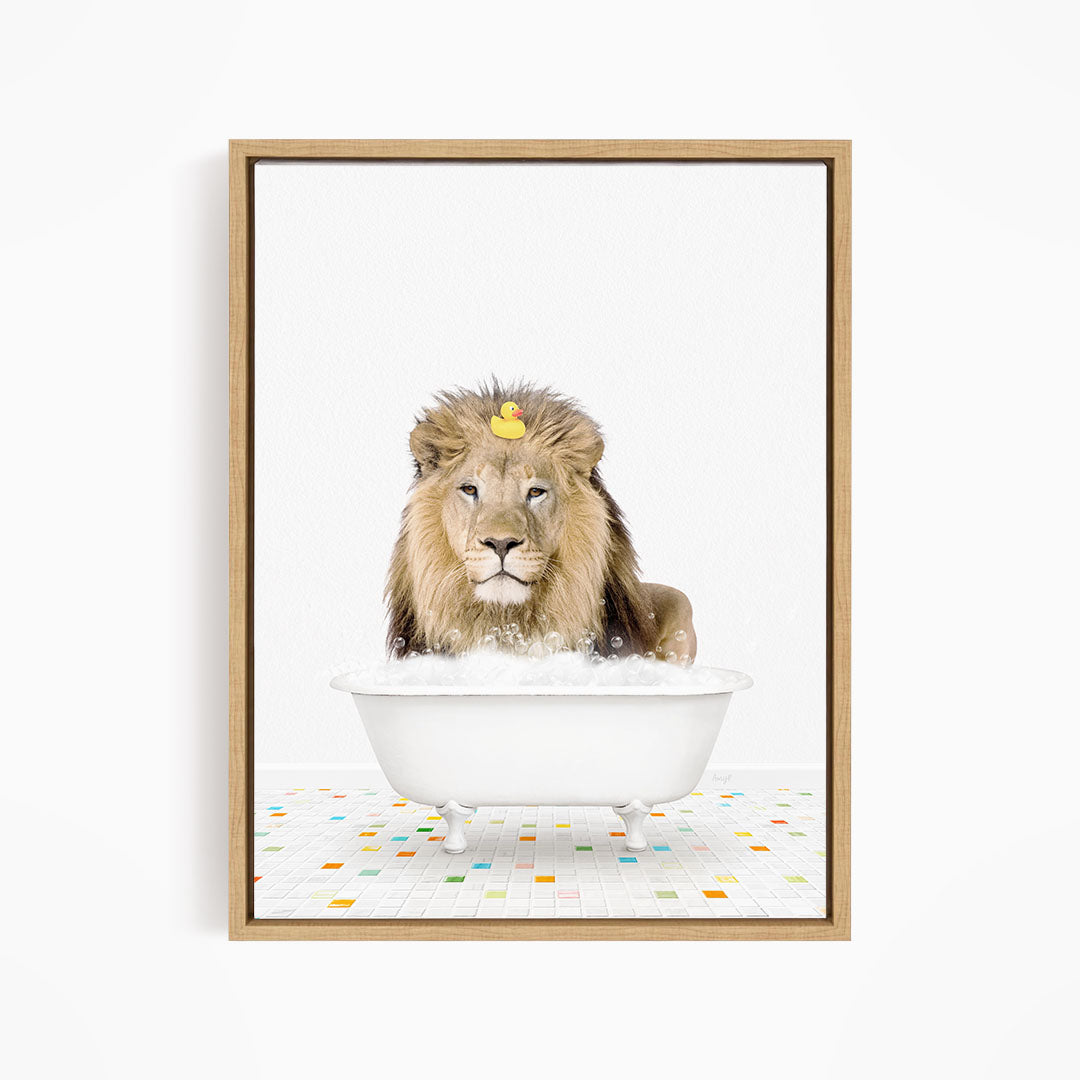 A lion is sitting in a white bathtub filled with bubbles, with a rubber duck floating on top of its head.